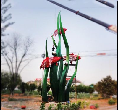 公園里擺放的水草里的不銹鋼創(chuàng  )意鯉魚(yú)雕塑